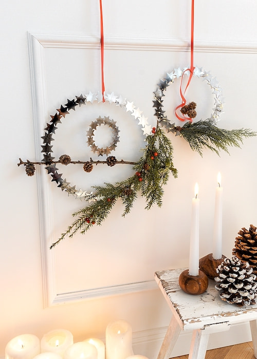 Gro�er und kleiner Kranz aus Metall mit gr�nen Zweigen als winterliche Wanddeko arrangiert